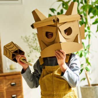 ダンボールで手作りした、節分の鬼のお面をかぶっている子ども。