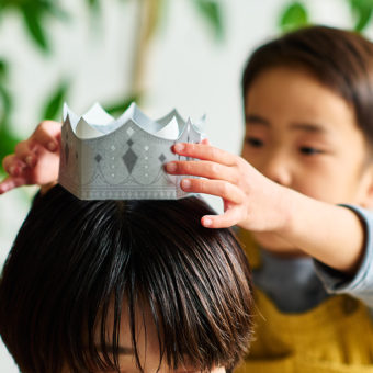 母の日チケットになっているティアラを、お母さんにかぶせてあげている子ども。