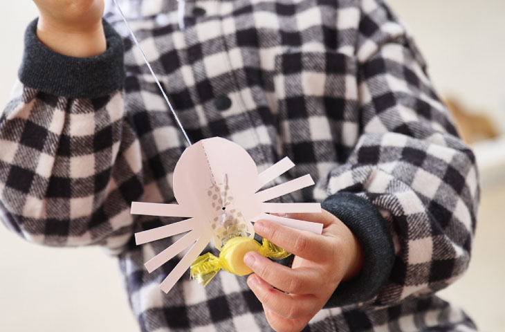 クモの巣の釣りゲームでお菓子を釣る子ども